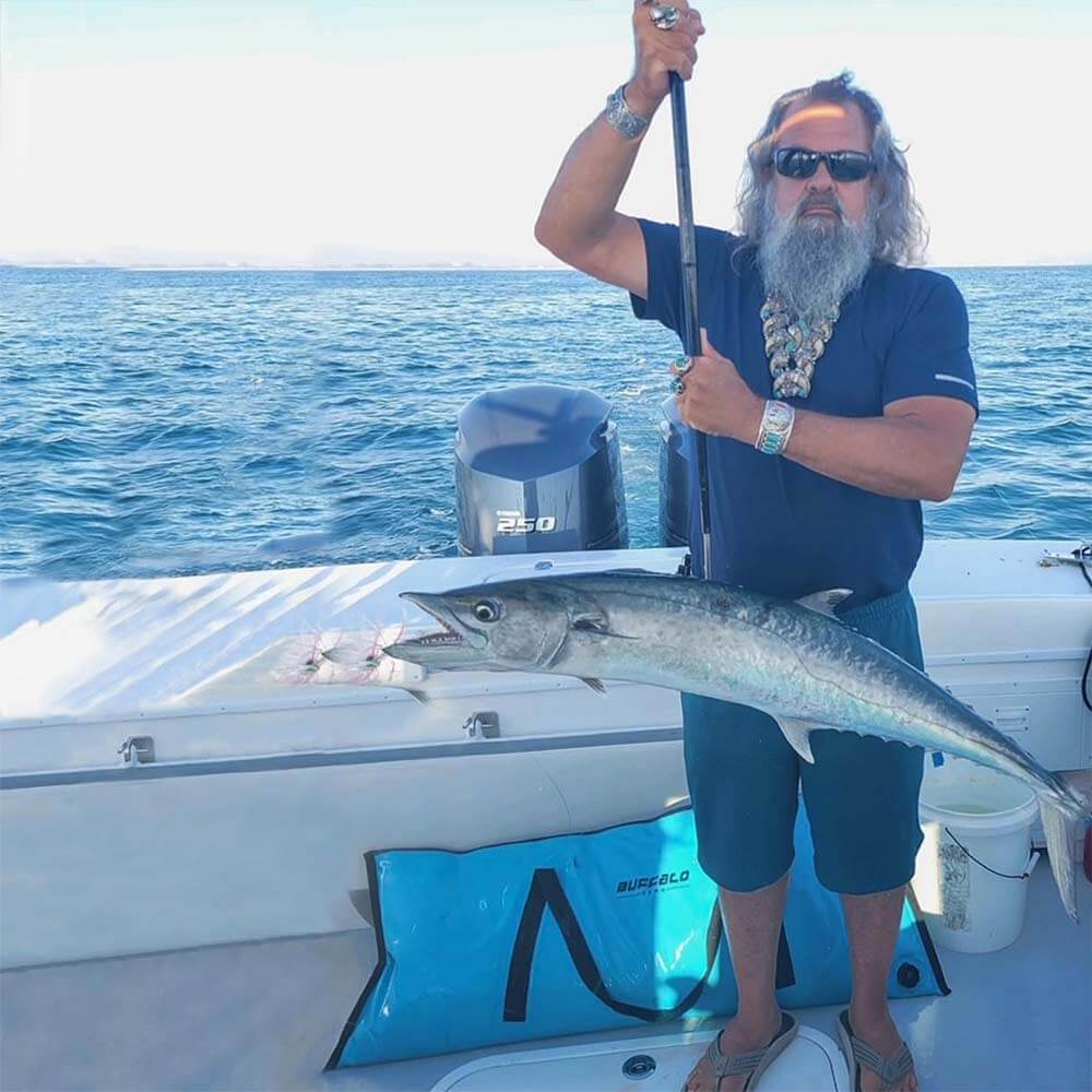 The angler had a swordfish stuck in his harpoon, and a blue Buffalo Gear fish cooler bag was placed behind him.