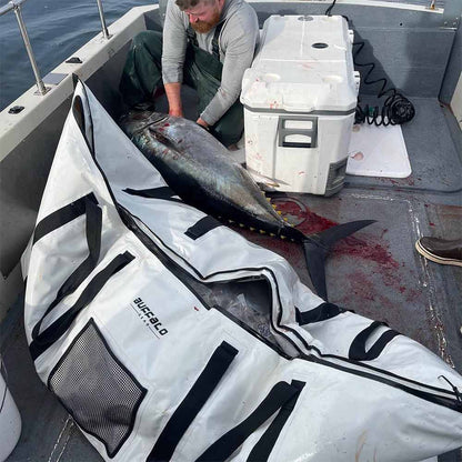 Chris placing a tuna with ice inside the Buffalo Gear insulated fish cooler bag, keeping the catch fresh and cold.