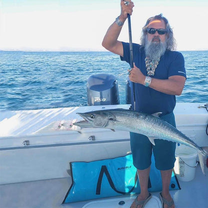 The angler had a swordfish stuck in his harpoon, and a blue Buffalo Gear fish cooler bag was placed behind him.