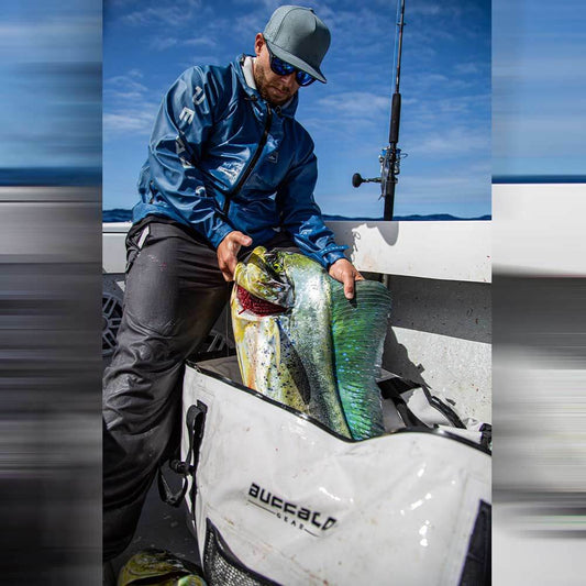 The angler is looking down at the mahi inside his Buffalo Gear bag; its 72inch Fish Cooler Bag can hold a lot of fish.